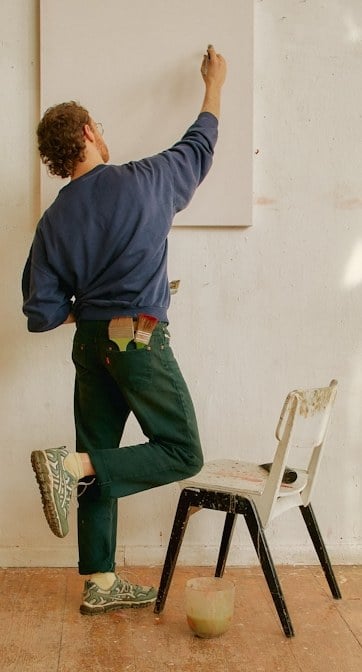 Artist hanging a canvas in a studio