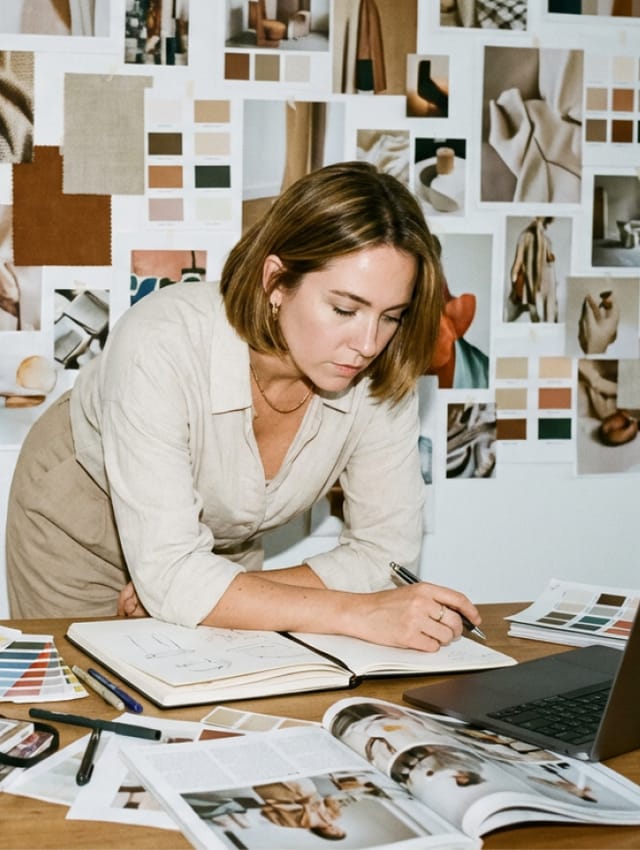 Creative working at a desk in front of a moodboard