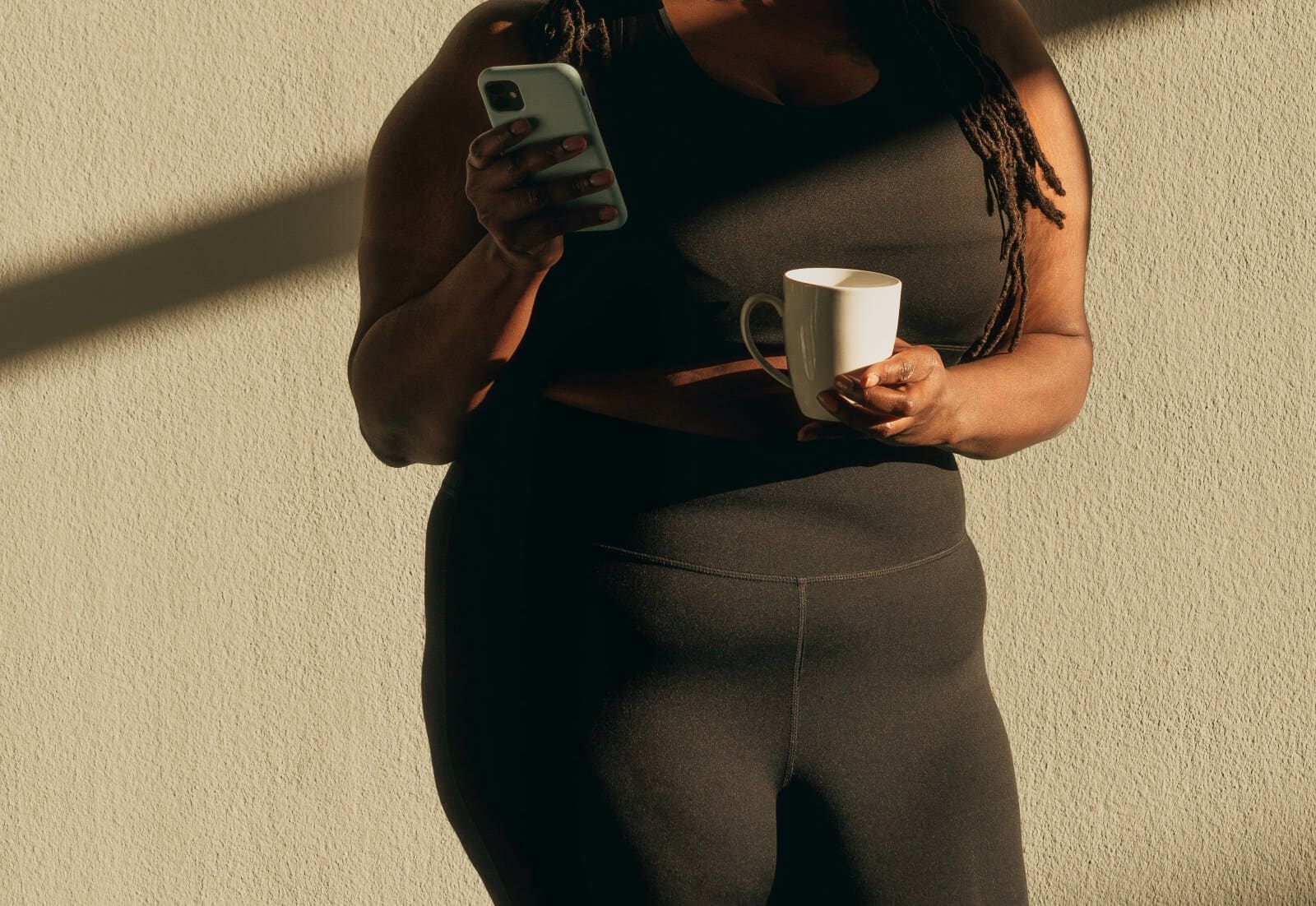 Small-business owner checking her phone in warm sunlight